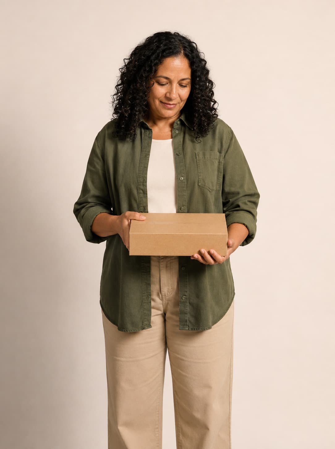 A woman holding a delivery box at home